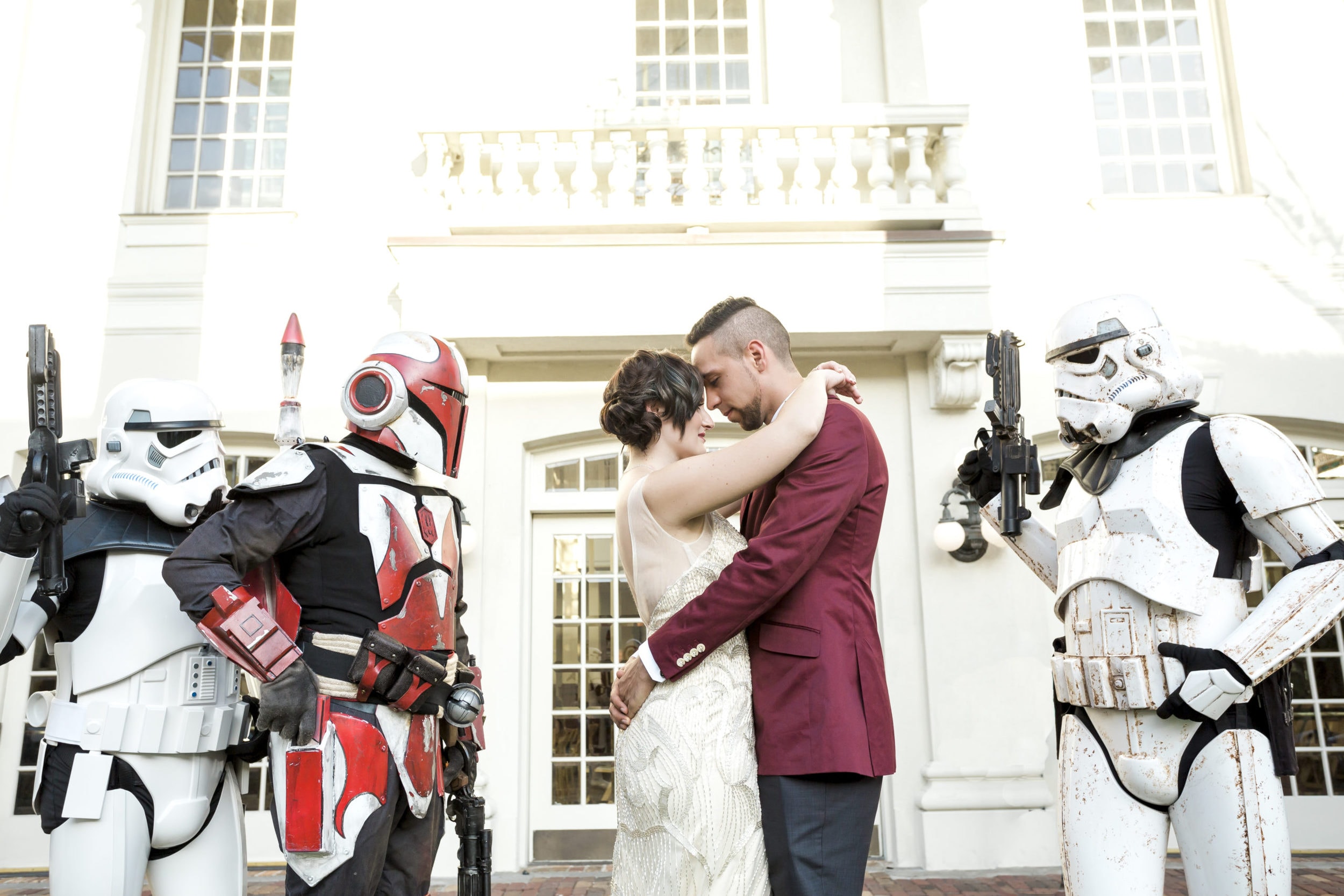 bride with groom holding each other with storm troopers in background atStar Wars Wedding