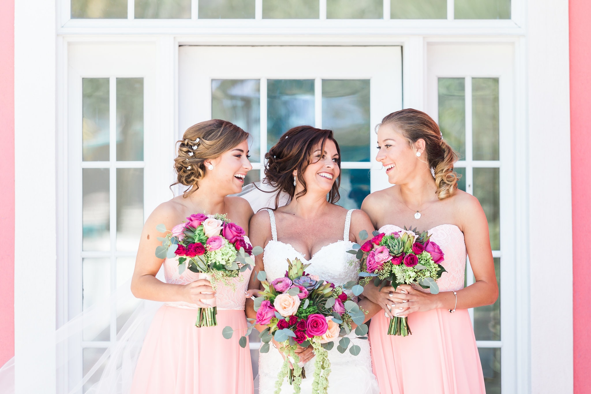 bridesmaids at tropical breeze resort with pink dresses and bouquets