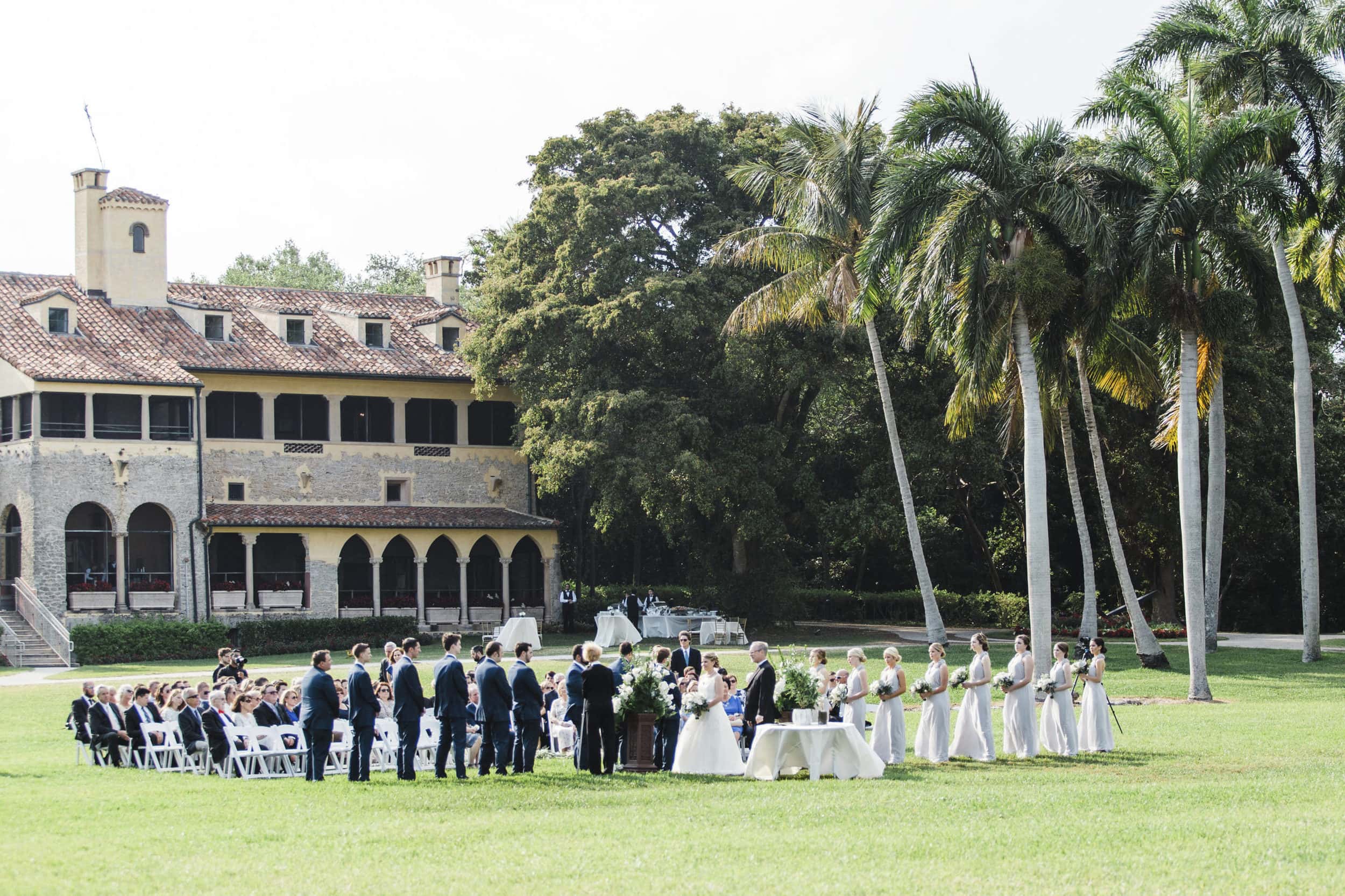 front lawn ceremony space with building and palm trees in background at deering estate wedding