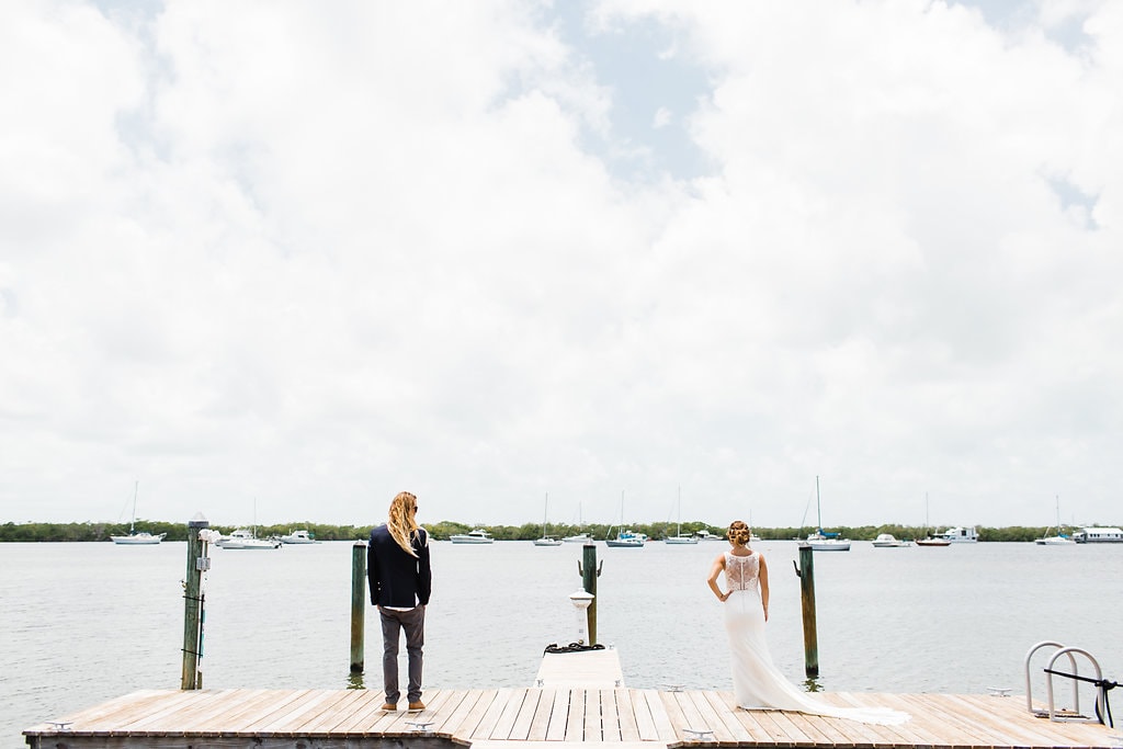 bride and groom standing at the end of the oceanfront dock at coconut palm inn florida keys wedding