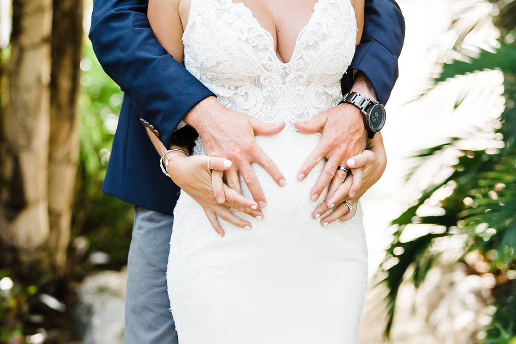 bride and groom hugging pregnant belly