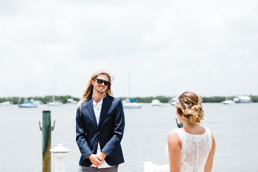 groom seeing bride for the first time at the end of the dock of coconut palm inn at a florida keys wedding