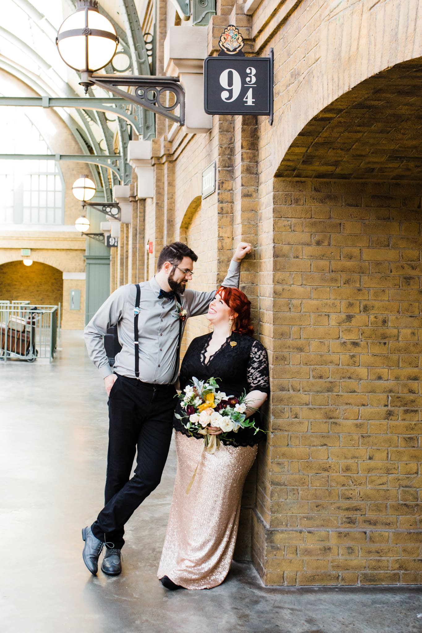 Couple standing underneath 9 3/4 platform sign at Hogwarts Universal Orlando waiting for the train for Hogwarts vow renewal