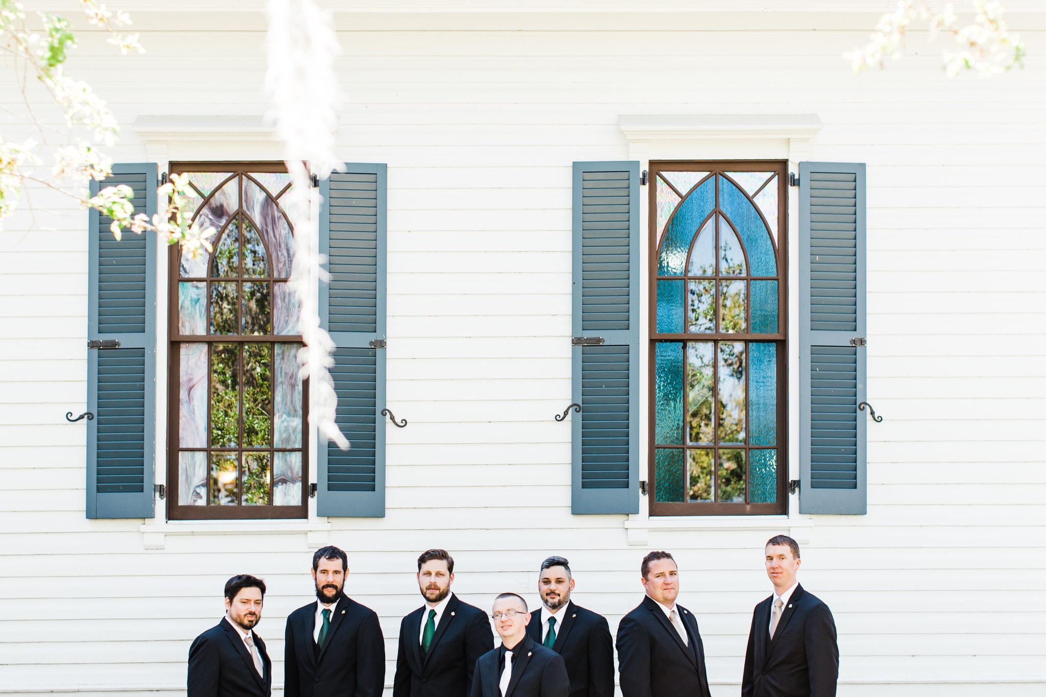 estate on the Halifax groomsmen photos in front of white chapel walls
