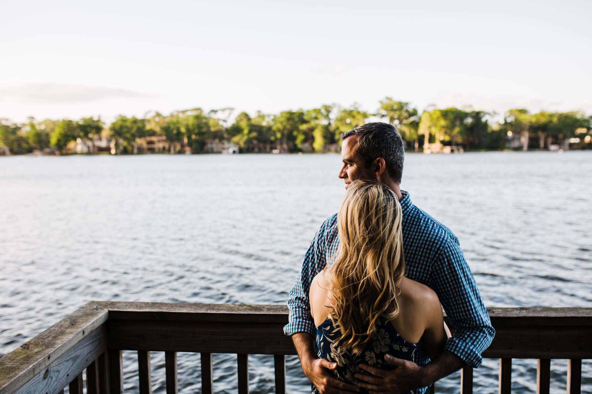 couple snuggling on dock at Kraft azalea gardens engagement session