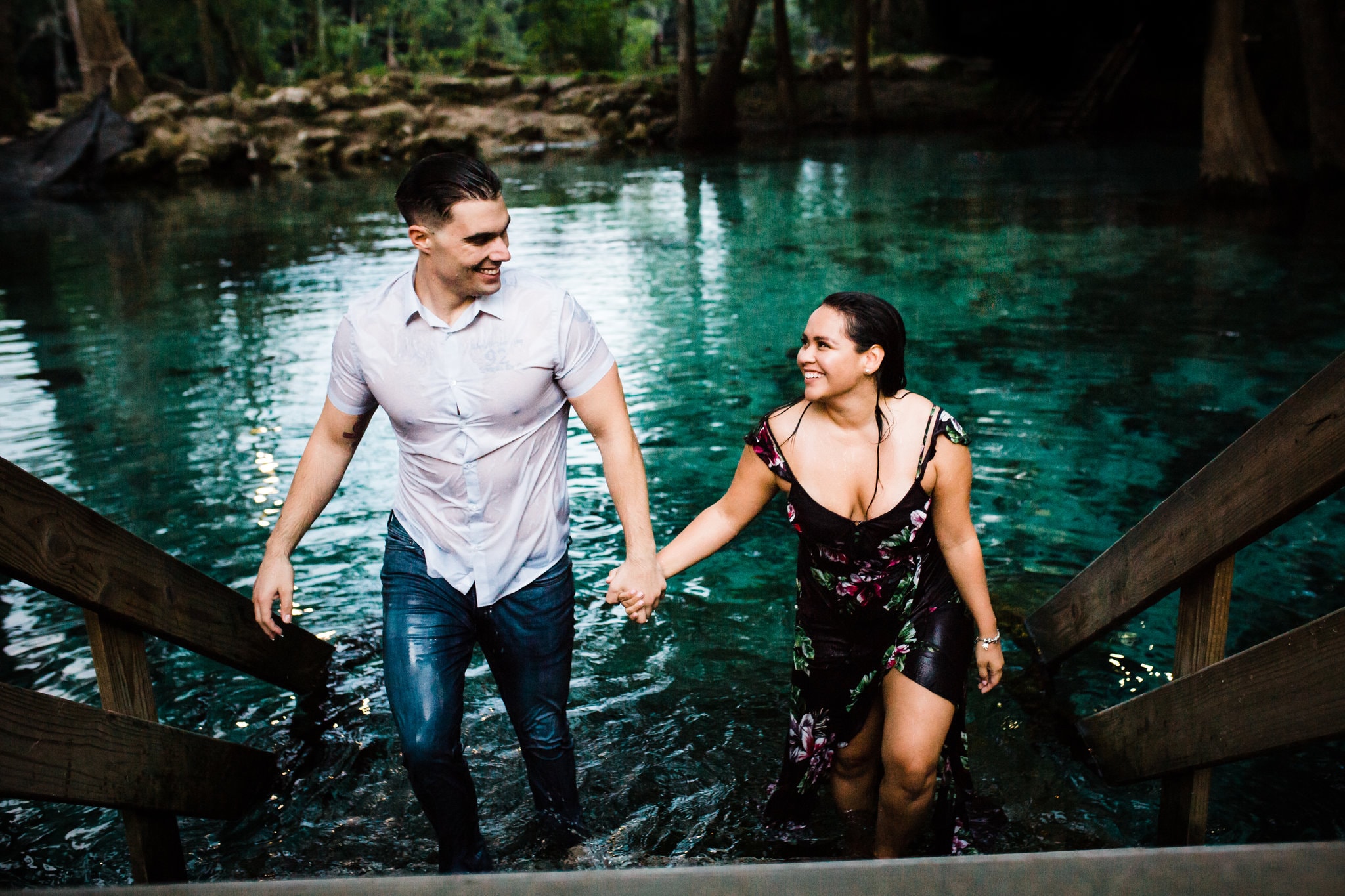couple walking out of the blue water during ginnie springs engagement session