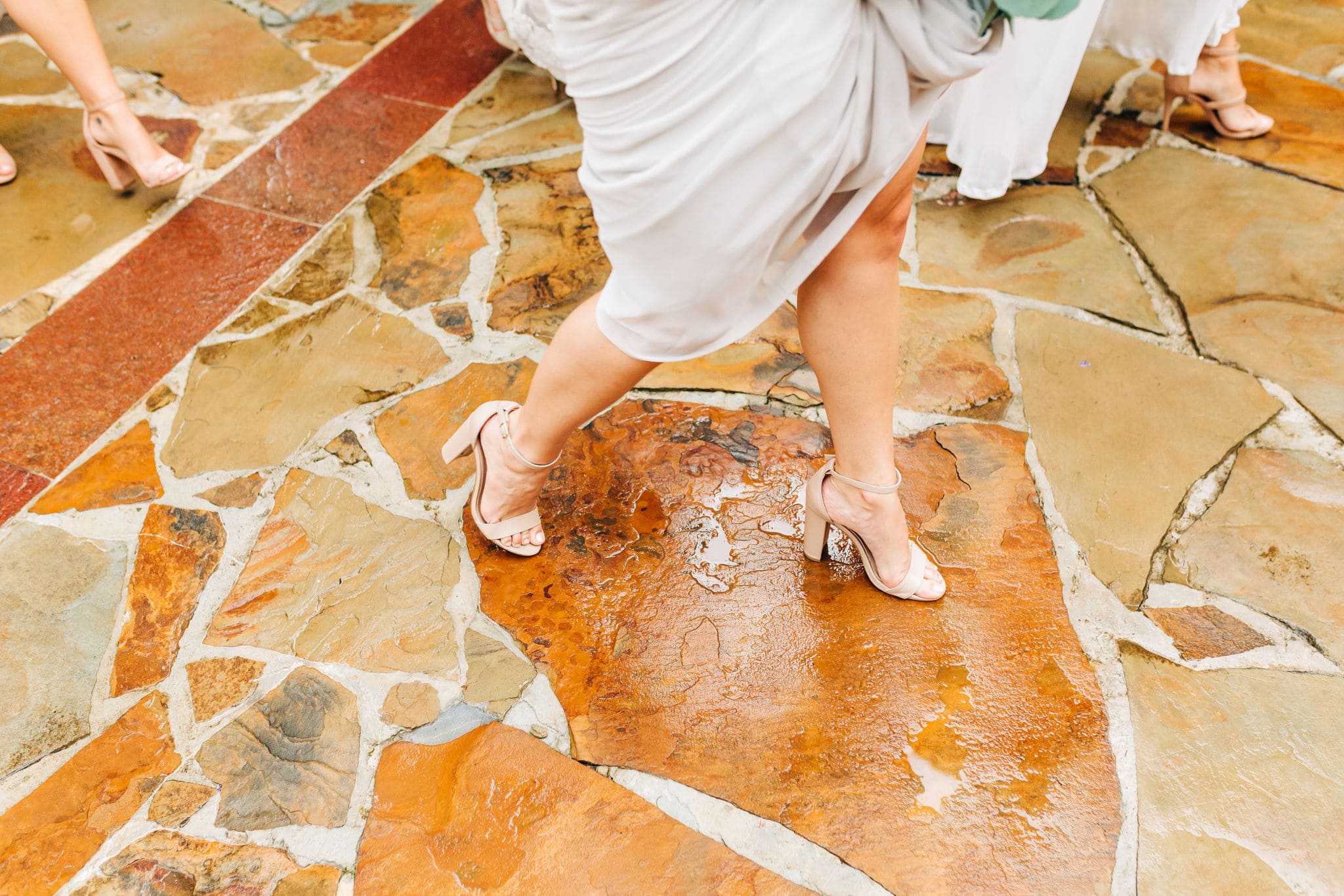 bridesmaid walking on cobblestone walkway in grey dress