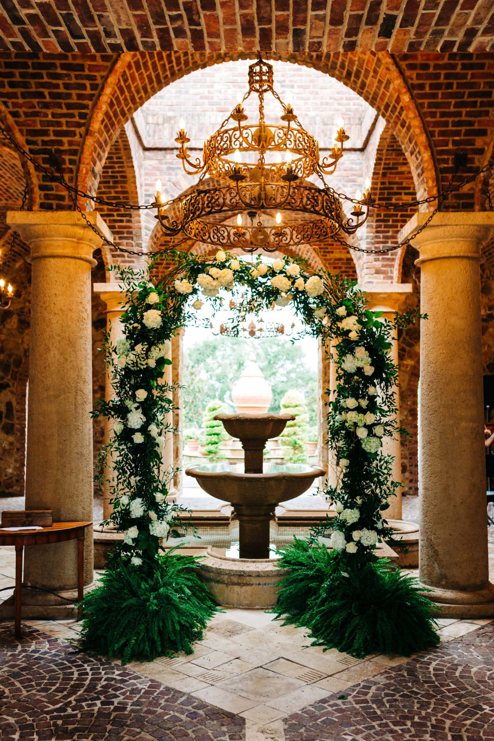 Bella collina atrium with arch in front of fountain decorated with white and green flowers