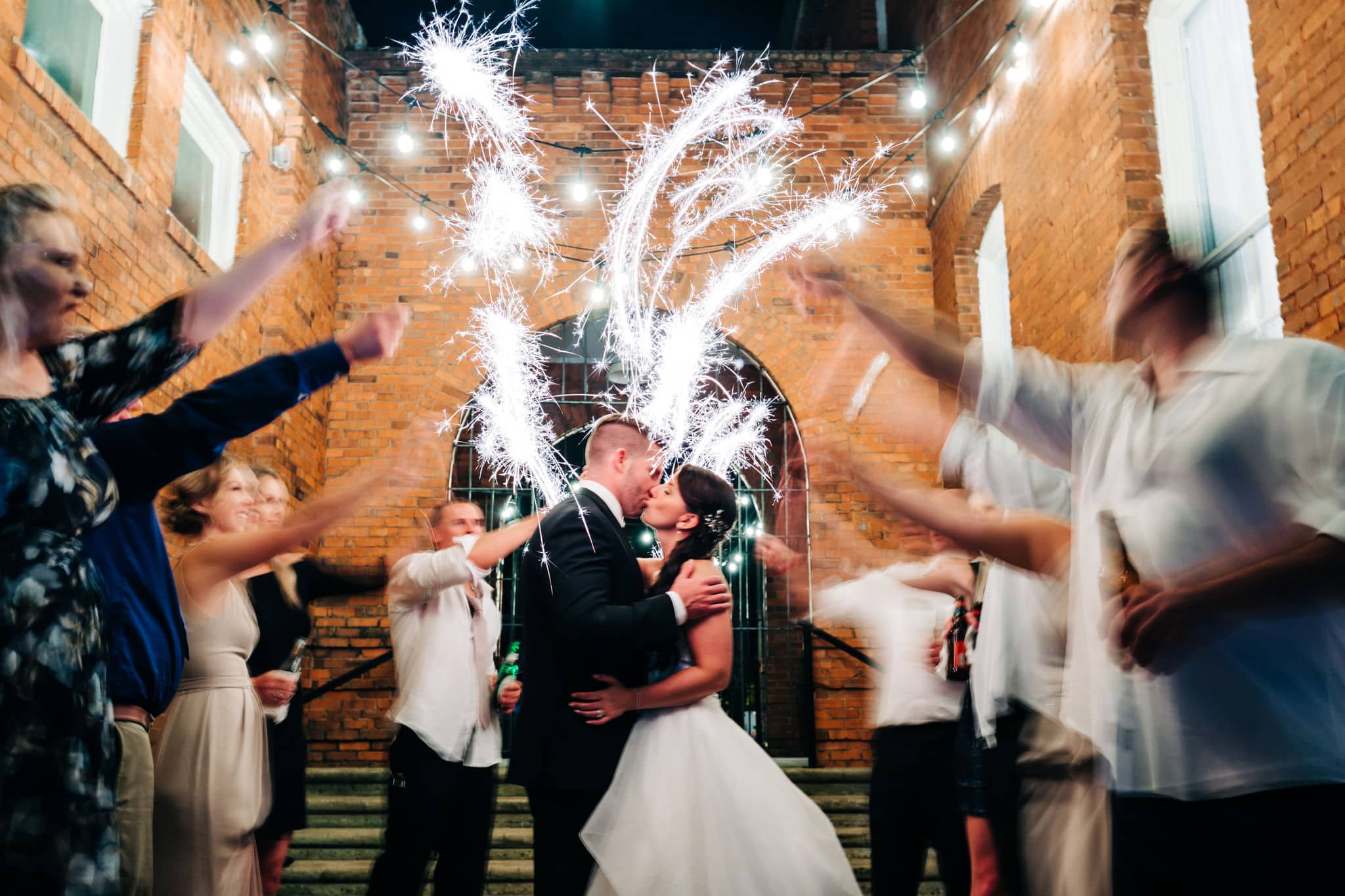 bride and groom kissing with slow motion sparklers at venue 1902