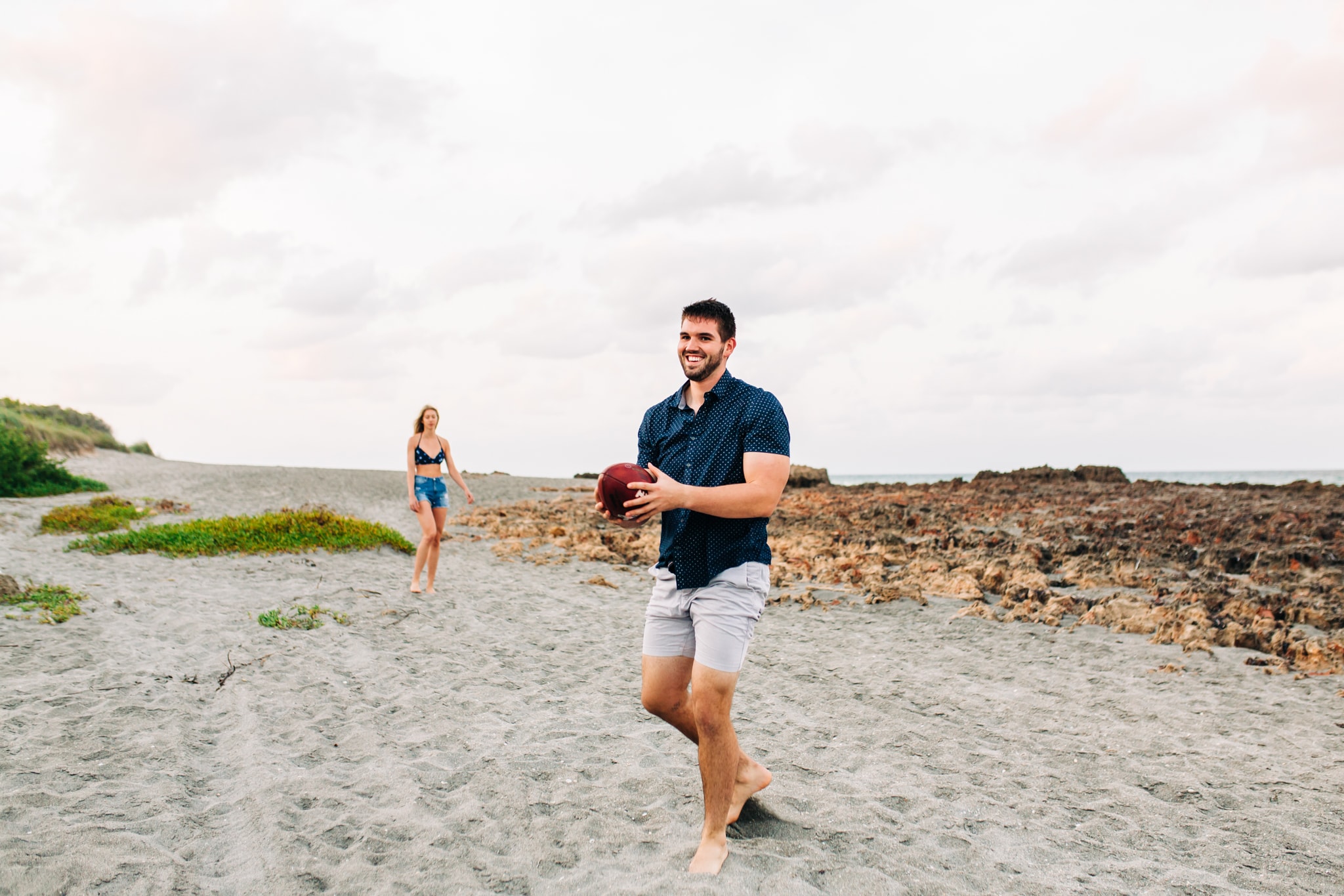 ny jets football player tossing football with fiancé during blowing rocks preserve engagement session