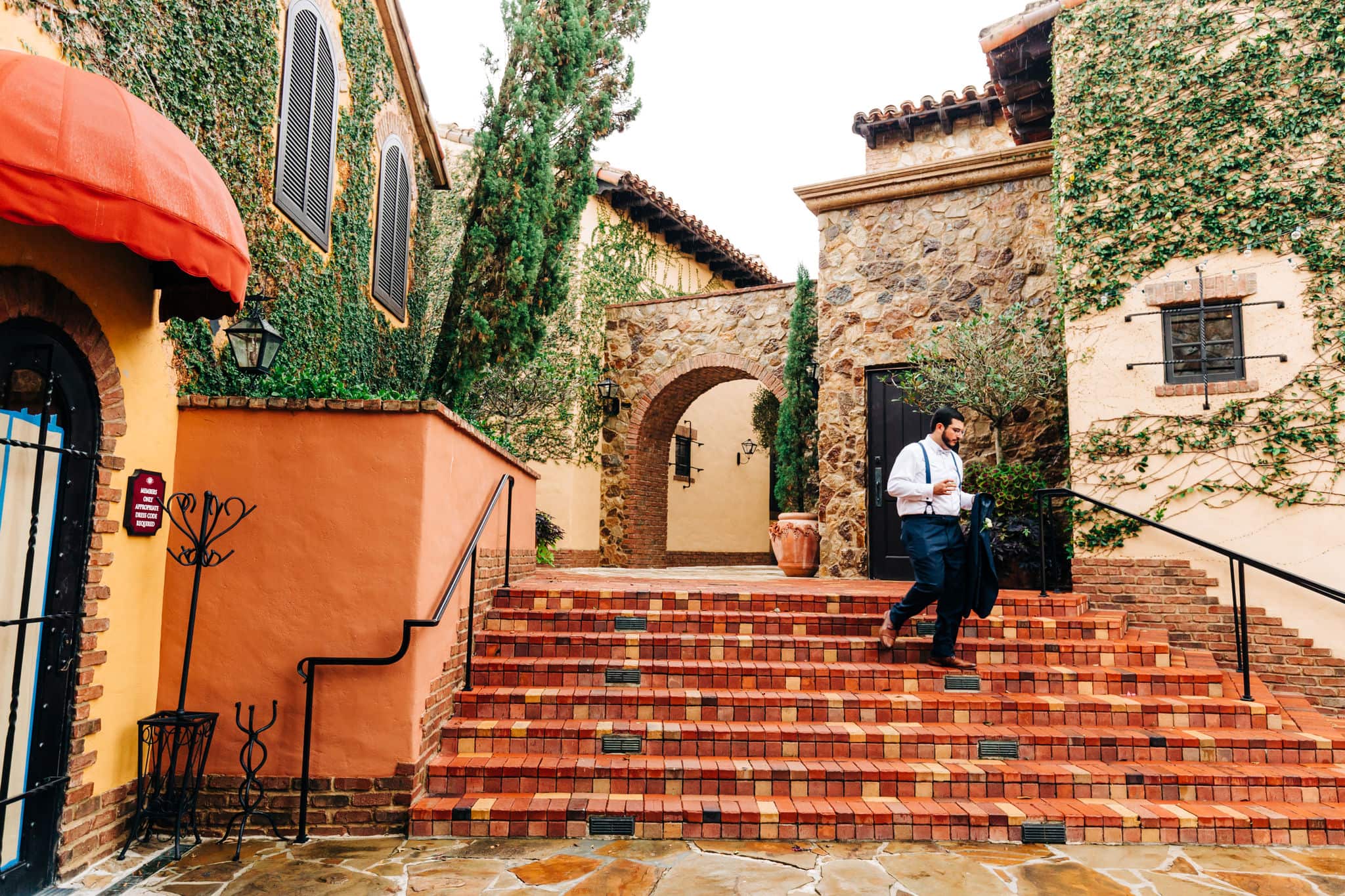 groomsman walking down tuscan steps at Bella Collina wedding venue 