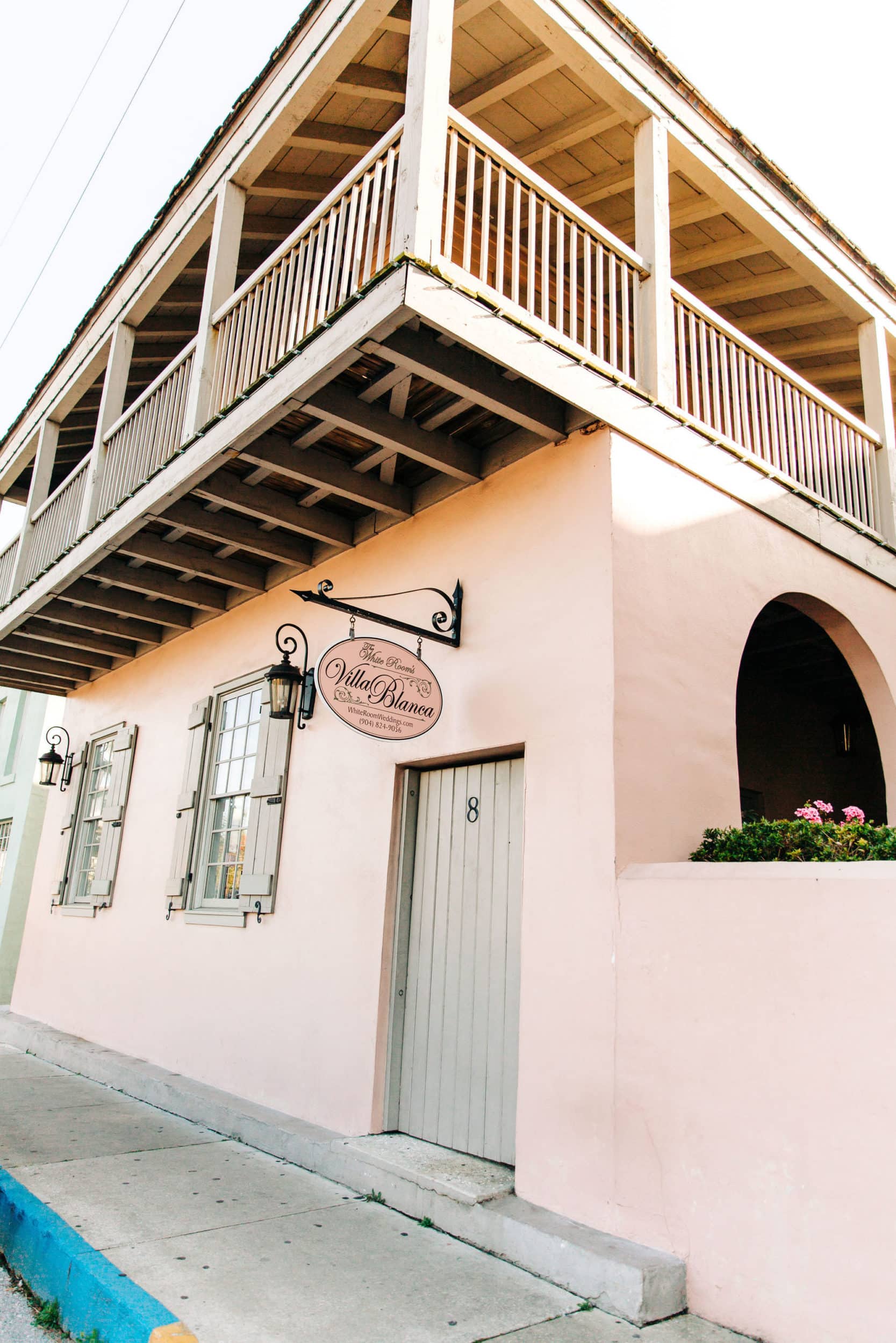 pink building with balcony with shutters and windows at white room wedding