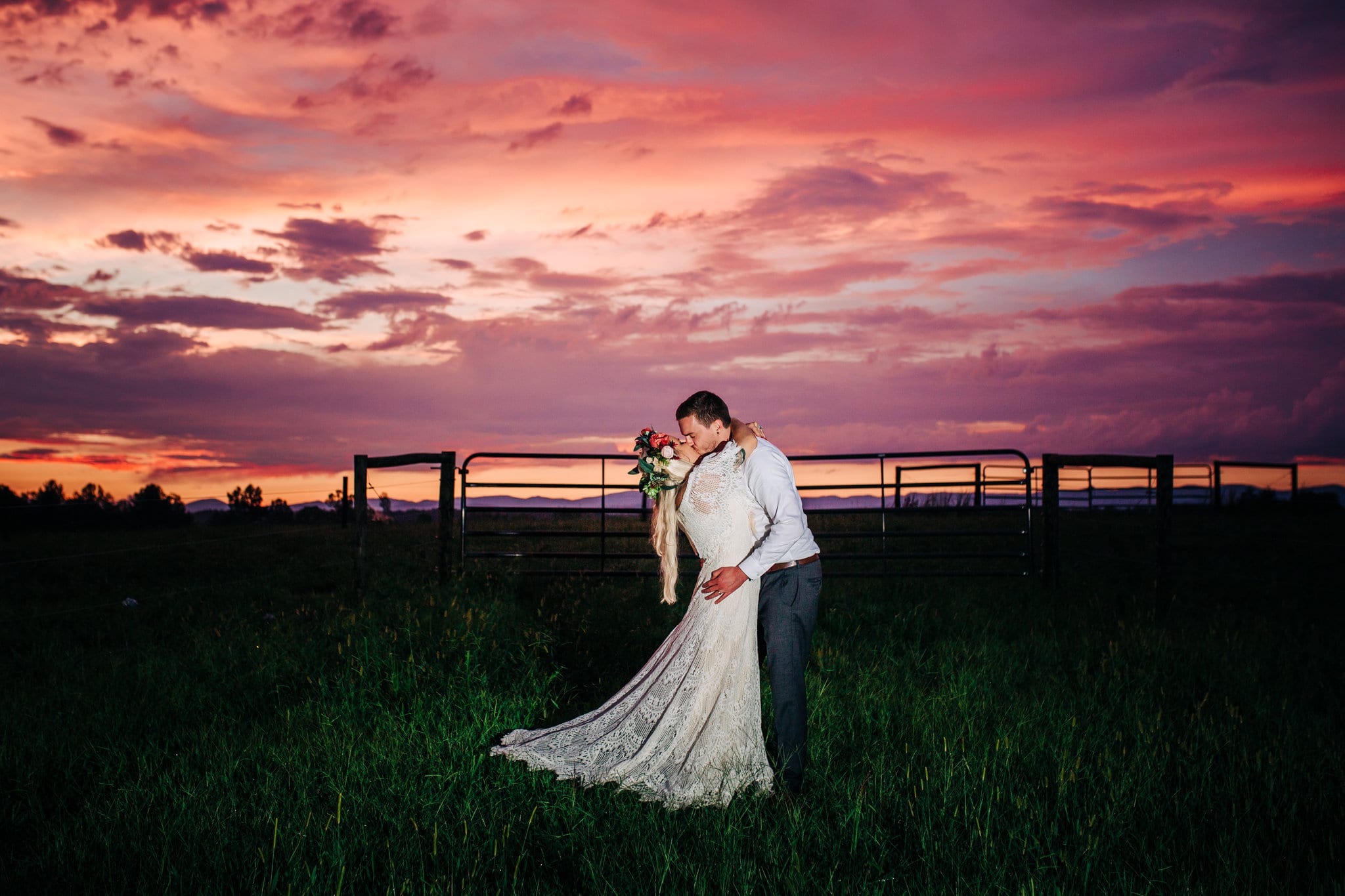 bride with lace dress with groom with grey suit with sunset in background at Boho Gambill Estate Wedding 