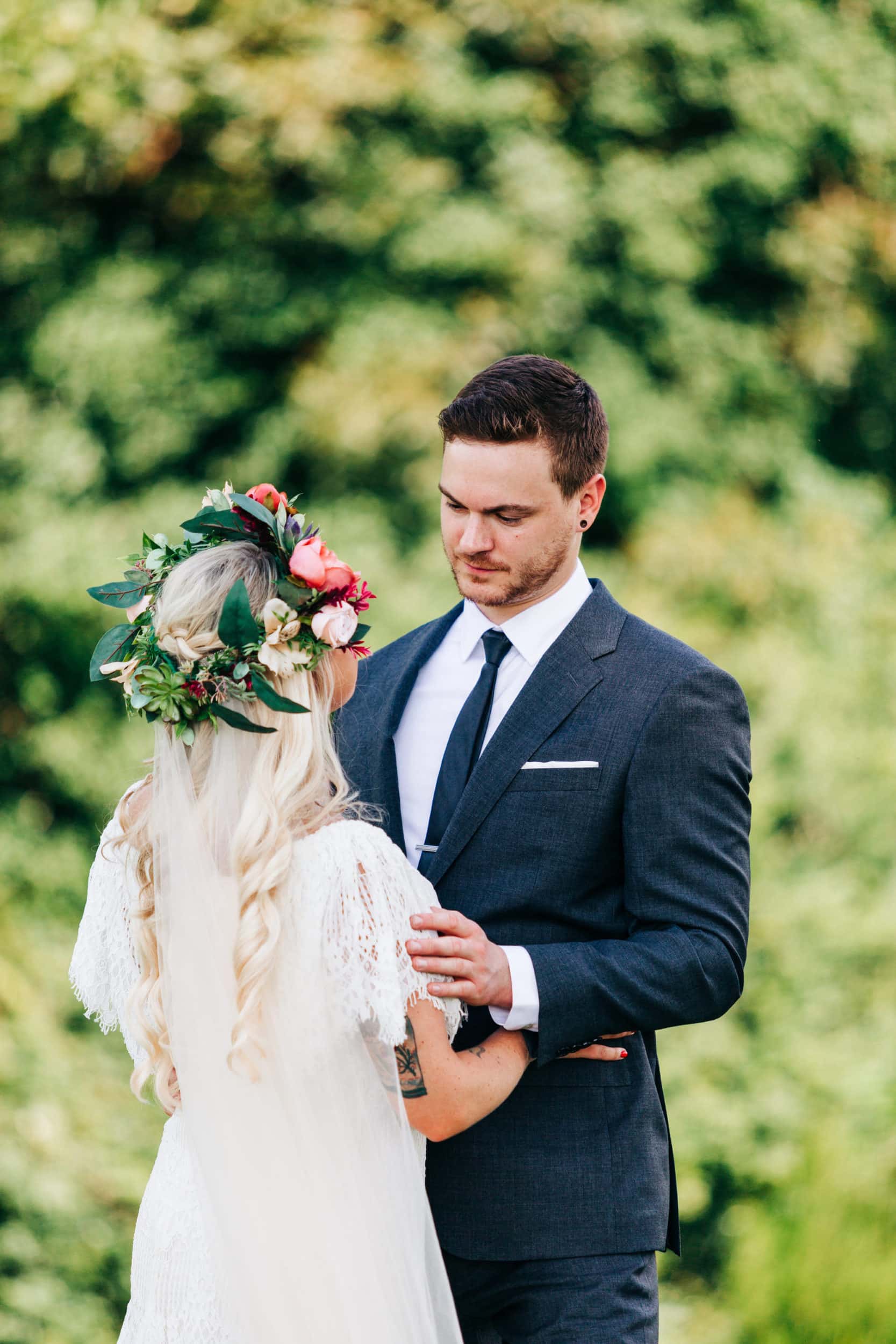 bride with lace white dress with pink and white flower crown with groom with grey suit at Boho Gambill Estate Wedding 