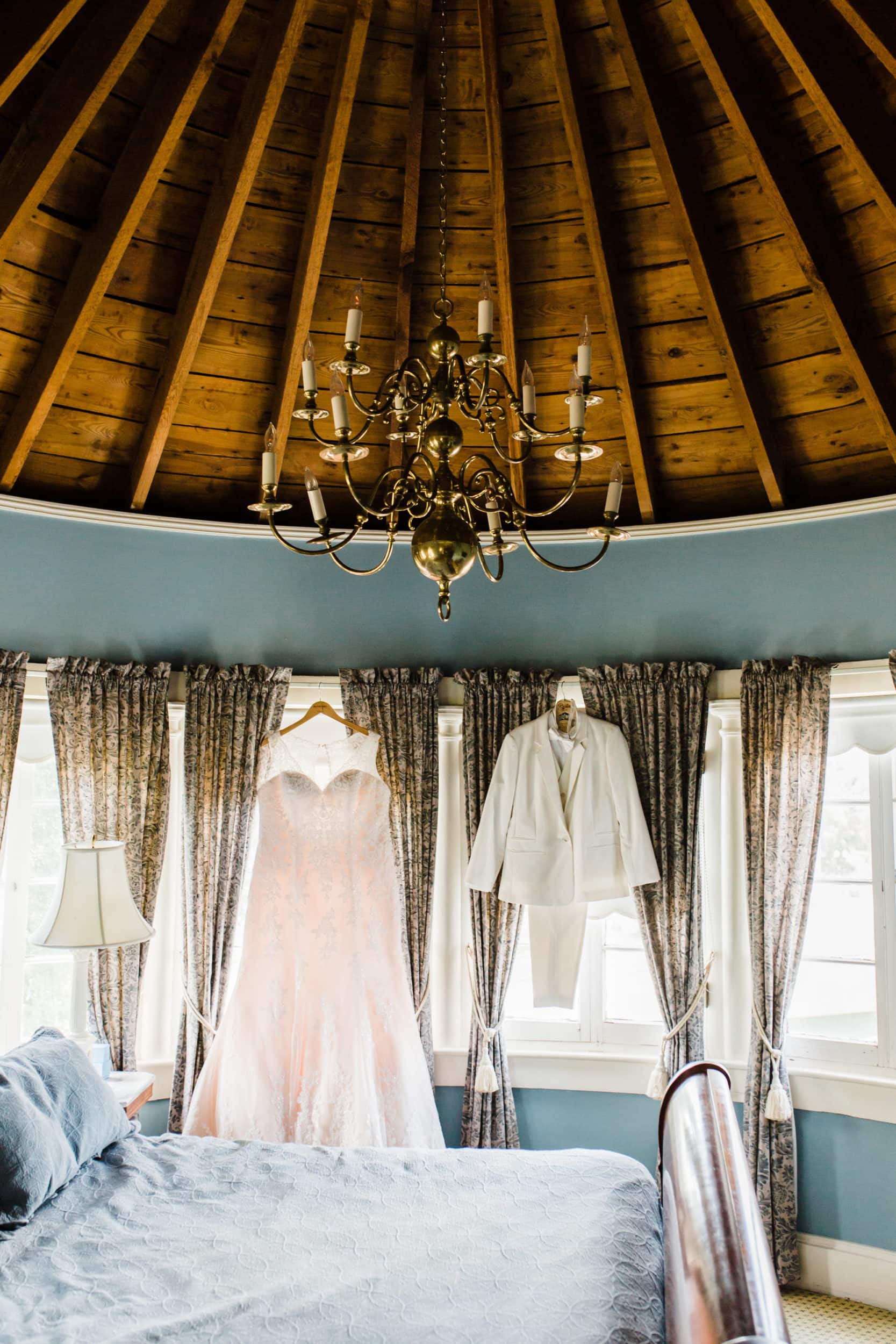 white lace bridal dress with white bridal suit with large wooden ceiling with chandelier with light blue building interior at Dr Phillips House Wedding