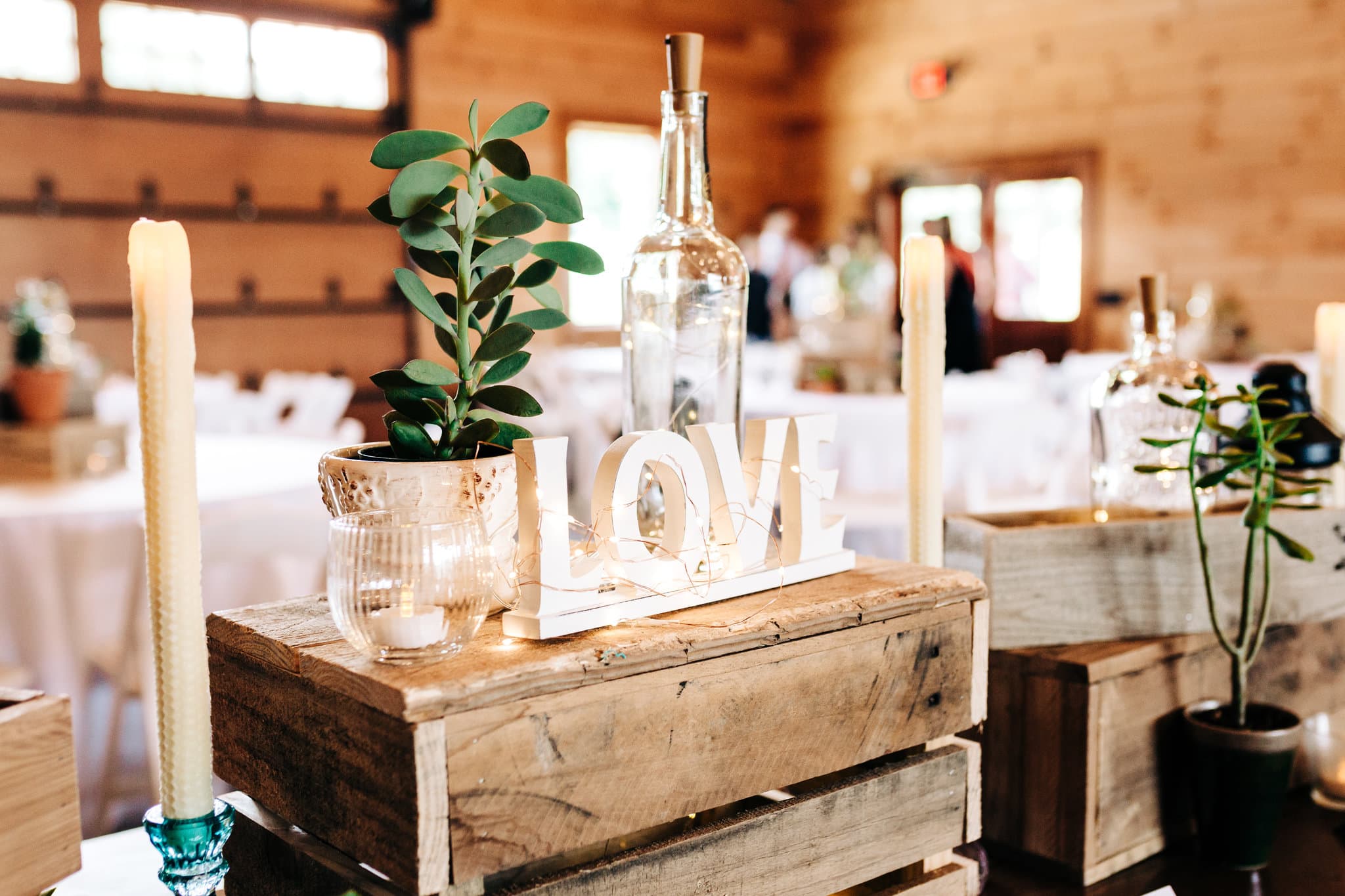 wooden crate with white love letters with candles with greenery at Boho Gambill Estate Wedding 