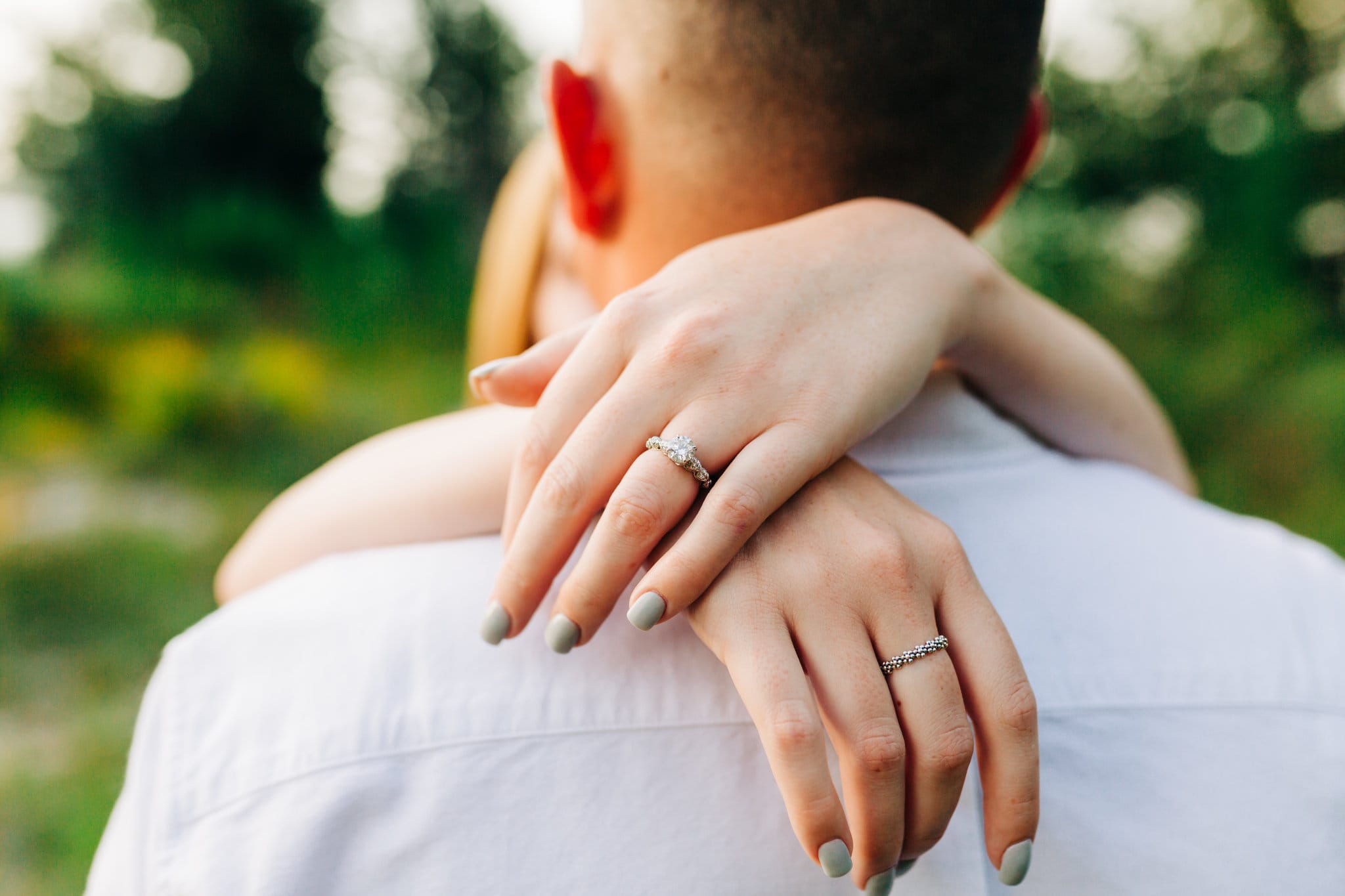 woman's hands with engagement ring with guy with white shirt at Baldwin Park Engagement Session